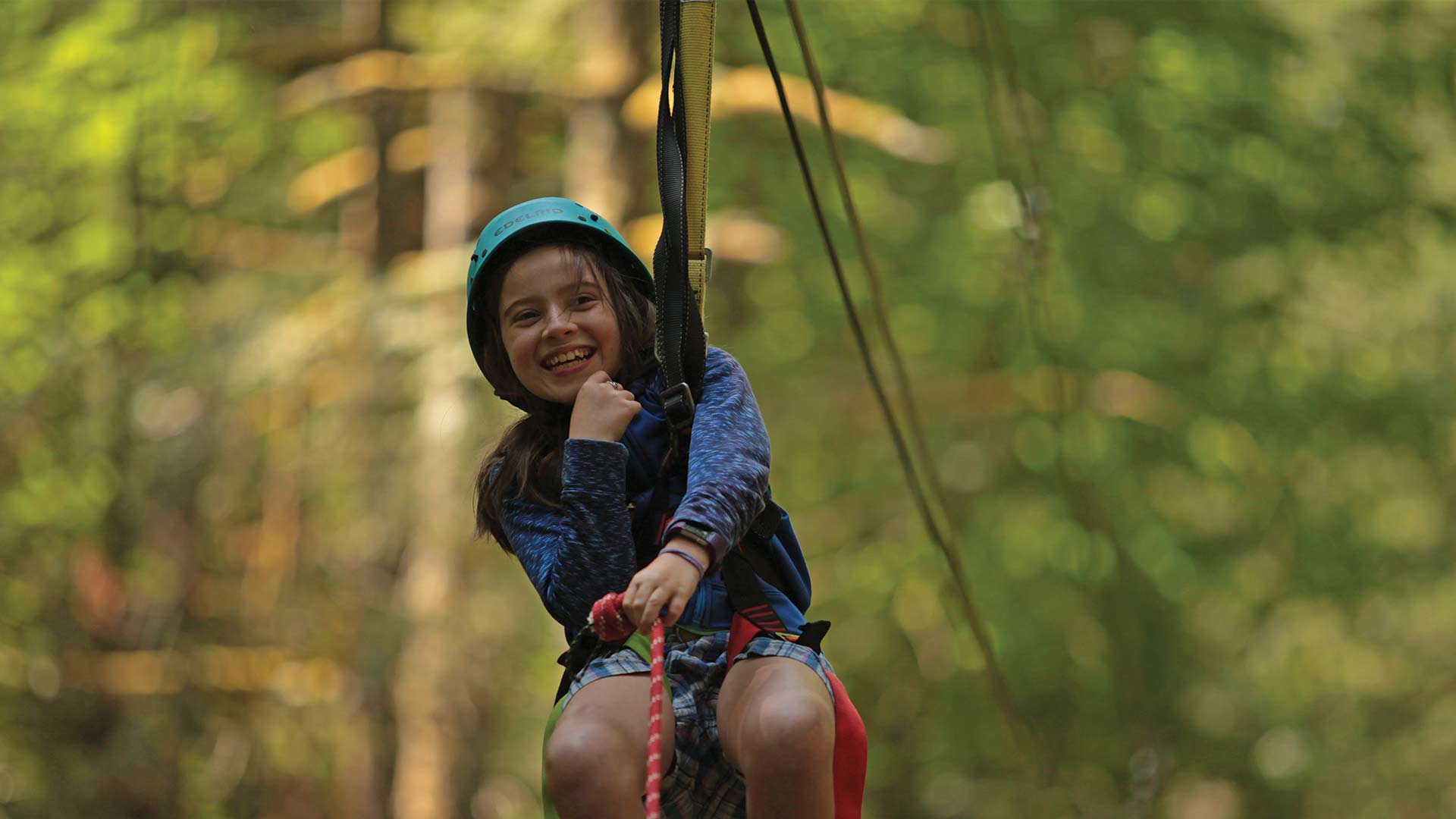 Young girl smiling on YMCA Camp Collins zipline
